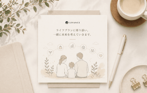 LIVANCEのサービスカードと家族・ライフステージのアイコン、デスクのコーヒーと文房具に囲まれたイメージ